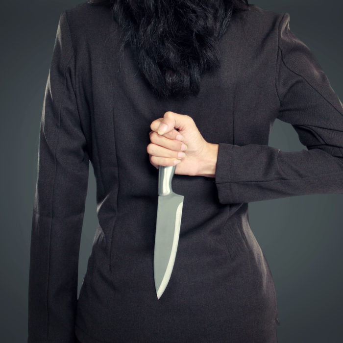 Woman holding a knife behind her back