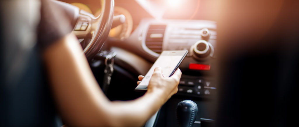 woman driving holding phone