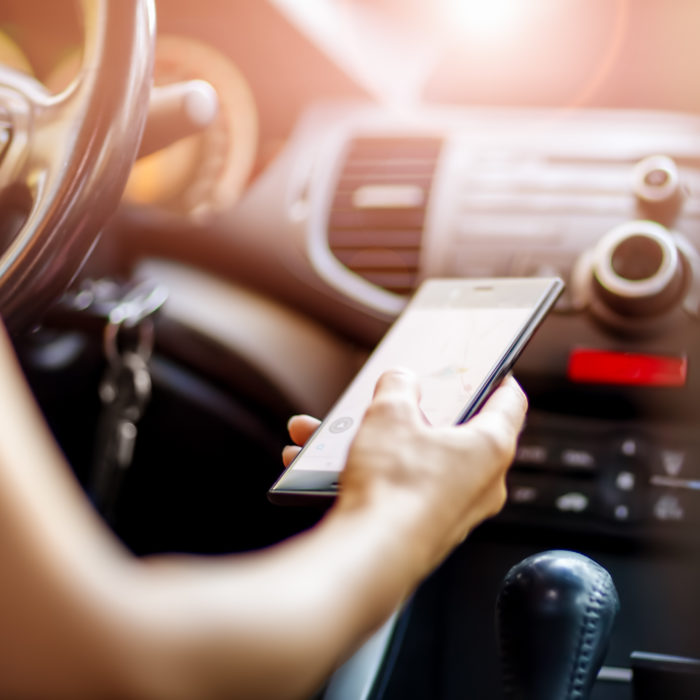 woman driving holding phone