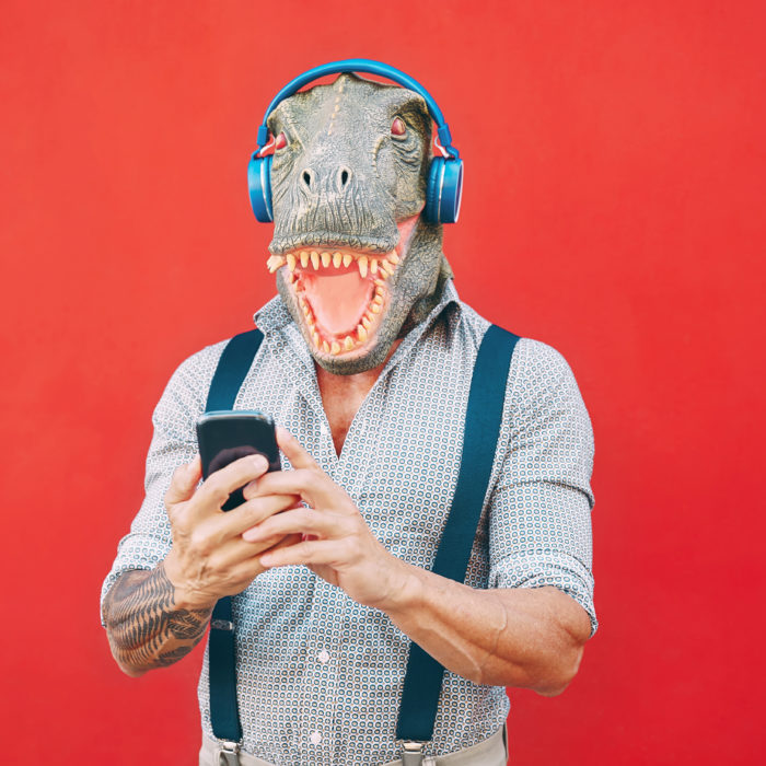 man with dinosaur mask wearing headphones